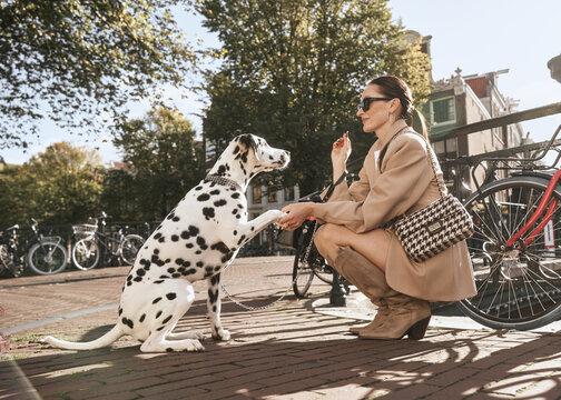 woman with a Dalmatian on a leash while posing in the Amsterdam city