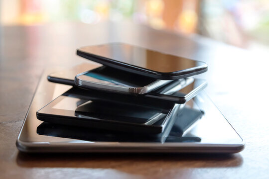 Stack of digital tablets and smartphones, close-up