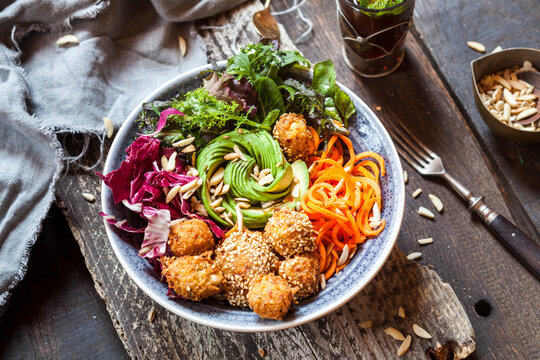 Rainbow salad bowl with carrots, lettuce, avocado, millet falafel and Moroccan mint tea