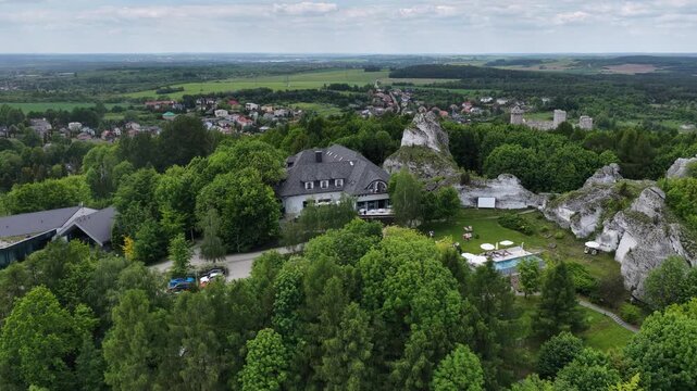 Aerial drone view of Ogrodzieniec and Podzamcze in southern Poland during spring, showcasing historic market square, village landscape, ponds and the Jura countryside scenery