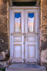 Fototapeta premium Weathered white door on stone building