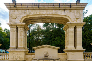 Obraz premium Symmetrical shot of an ancient stone triumphal arch in park