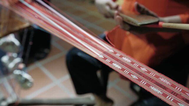 Close up of hands crafting a fabric using an old handloom. Traditional textile production in vietnam