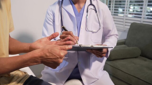 Doctor in white coat writing notes while listening to a patient during a medical consultation in a clinic or office, showing healthcare support, diagnosis, and professional care
