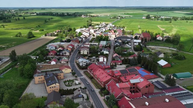 Aerial drone view of Zarnowiec village in Silesian Voivodeship, Poland, during spring, showcasing historic market square, traditional rural architecture and green countryside landscape
