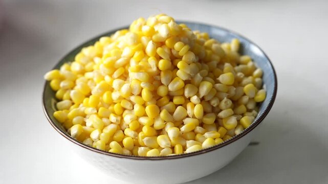 Fresh sweet corn kernels piled in a white bowl, showcasing their bright yellow color and natural texture. A healthy and versatile ingredient for cooking, salads, soups, and snacks