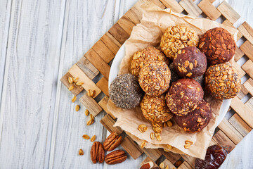 Fototapeta premium Healthy Organic Energy balls Muesli Bites with Nuts, Cocoa, Chia and Honey - Vegan Vegetarian Raw Snacks or Food. copy space. Flat lay