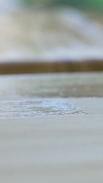 Brush spreads enamel over wood, reinforcing structure while adding shine. Protective layer enhances texture, shielding surface from moisture. Even strokes ensure seamless application