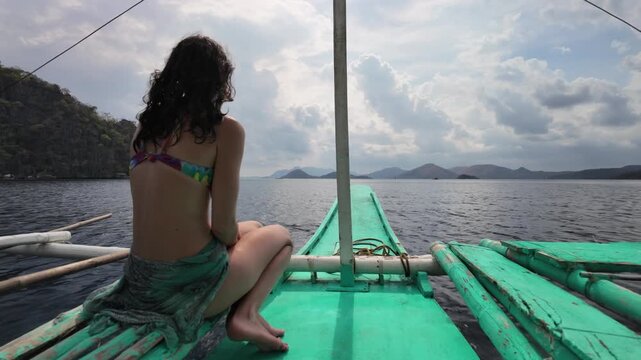Woman sitting on traditional Filipino bangka boat in Coron Palawan