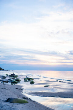 Rocky beach coastline on Ruegen island in Germany during sunset over the Baltic Sea. Travel, nature and seaside landscape with calm evening atmosphere