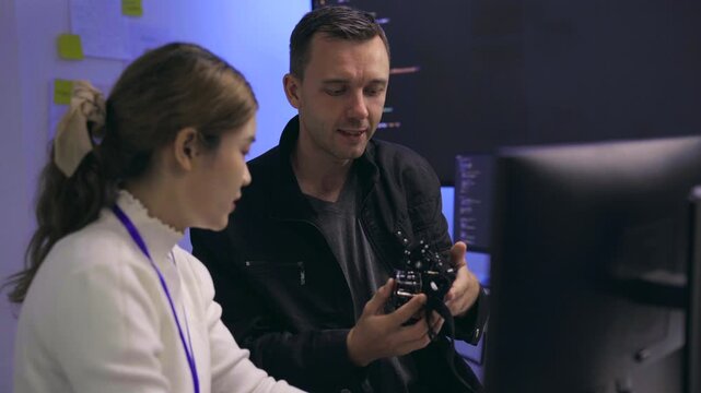 Tech developers collaborating on a robotic device in a lab