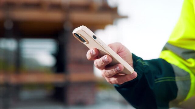Architect, chat and hand with phone at construction site, info and communication with contact on web. Civil engineer, texting and person with mobile for message, outdoor and property development