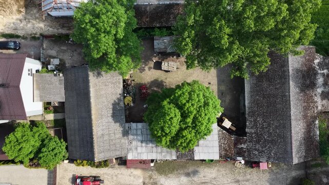 Aerial drone view of Chlina village in Silesian Voivodeship, Poland, featuring historic church, agricultural fields and rural countryside landscape during a sunny spring season. Church near the lake