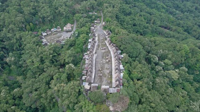 Aerial view of Bena Traditional Village with its iconic thatched roofs nestled in the lush green forest of Kecamatan Jerebuu, Nusa Tenggara Timur, Indonesia.