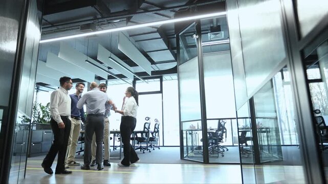A group of people are walking through a large office building