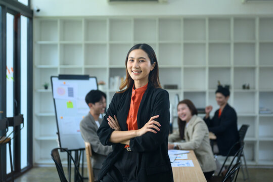 Confident Asian Businesswoman Leading Team Meeting in Modern Office
