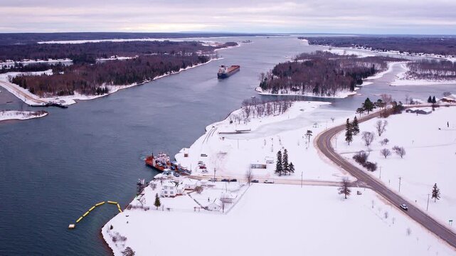 Drone shot of a commercial ship navigating the St. Marys River toward Sault Ste. Marie