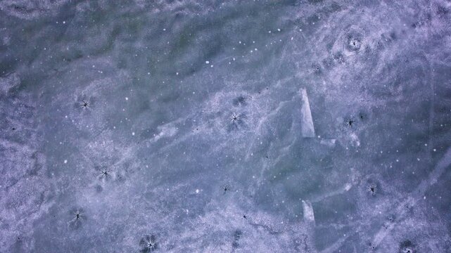 Drone footage looking straight down at frozen lake ice patterns on the Great Lakes