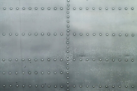 Close-up of industrial riveted weathered metal plane aviation panel texture material