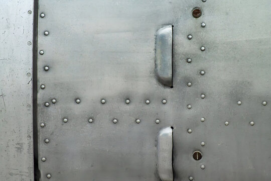 Close-up of industrial riveted weathered metal plane aviation panel texture material