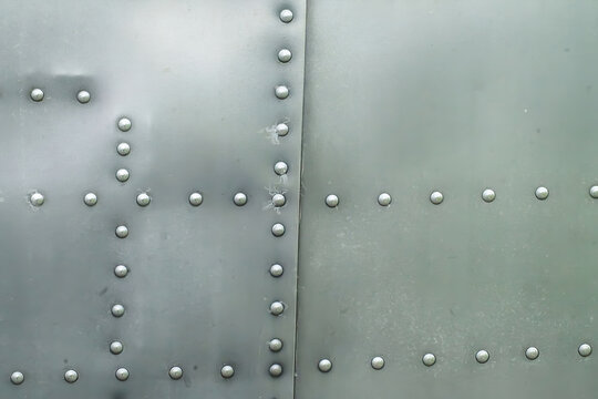 Close-up of industrial riveted weathered metal plane aviation panel texture material