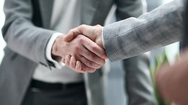 Two hands firmly shake, symbolizing agreement or partnership