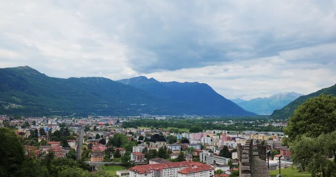 Bellinzona, Switzerland, May 18, 2026. High angle panning shot overlooking the alpine city and Ticino valley, showing mountains and medieval stone fortifications of Castelgrande.