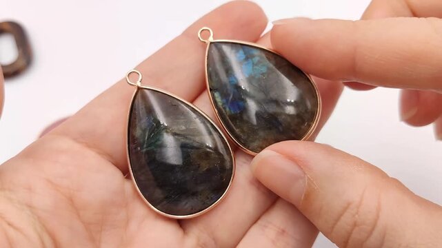 These polished teardrop gemstones feature metallic gold frames and loops for attachment, providing high-end components for crafting necklaces, earrings, and custom accessories