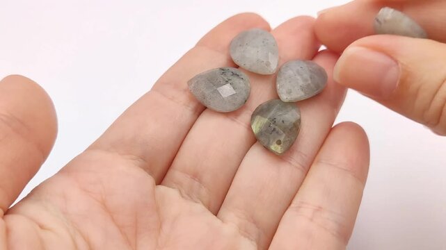 These natural labradorite teardrop pendants showcase delicate gray hues and multifaceted surfaces for sophisticated jewelry design and unique accessory creation projects