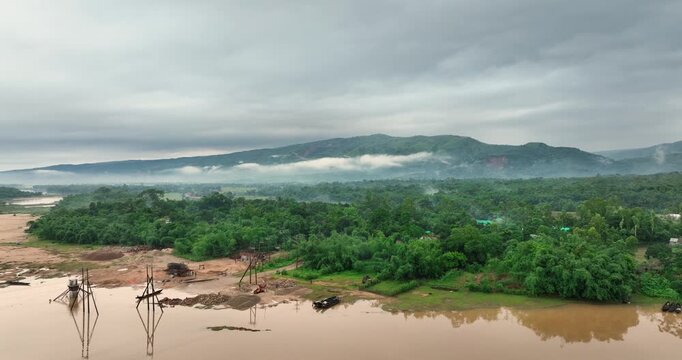 Aerial view of Tanguar Haor wetlands with lush green forests and misty mountains in Sunamganj District, Sylhet Division, Bangladesh.