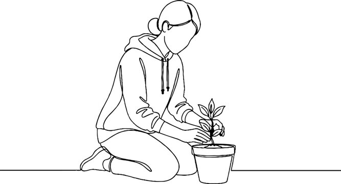 Person carefully tending to a small potted plant indoors.