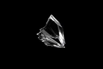 Naklejka premium Flying broken glass shards isolated on a black background, with sharp transparent fragments, glossy reflections, and dramatic studio lighting.