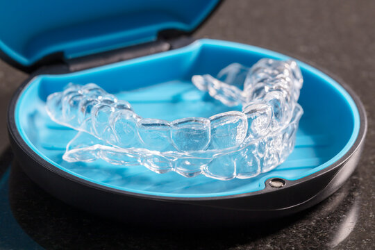 Transparent orthodontic retainers or braces in a box container