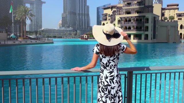 A beautiful tourist woman in a white dress on a sightseeing trip through downtown Dubai, UAE