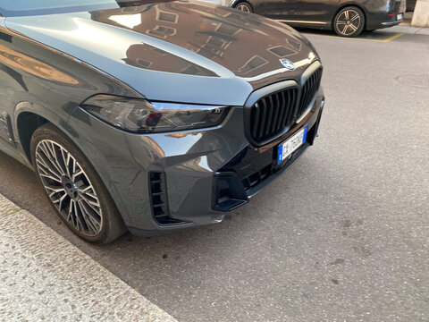 Modern dark grey BMW X5 M Competition parked on a city street