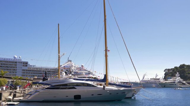 Elegant sailing yacht moored in Monaco marina with luxury vessels and waterfront scenery, representing wealth, prestige and Mediterranean nautical lifestyle 4K. Monaco 7 May 2019
 
