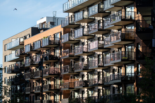 Dense balcony grid covers a modern apartment building in Oslo, Norway, where residential architecture repeats across the facade in afternoon light