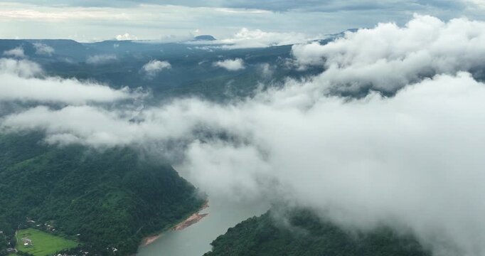 Aerial view of Tanguar Haor wetland surrounded by lush green hills under a thick layer of white clouds in Sunamganj District, Sylhet Division, Bangladesh.