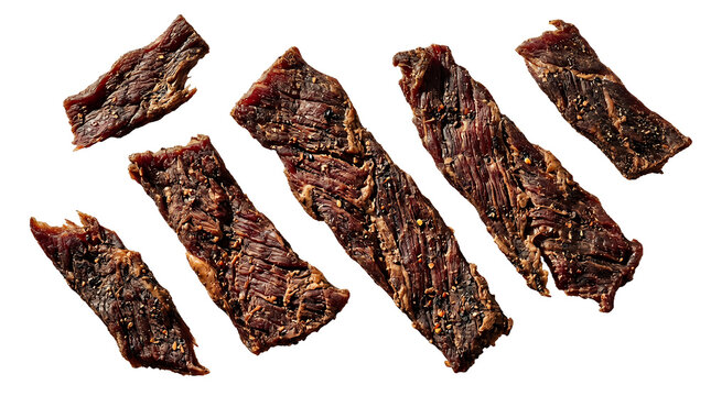 Beef jerky strips are scattered across a white surface to highlight the dried and cured meat texture.
