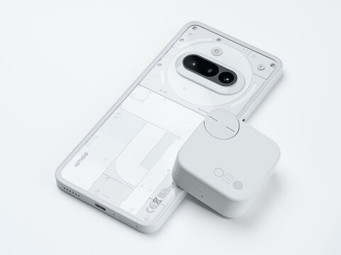 Dnepr, UKRAINE 04.08.2026 : Nothing Phone (3a) lying next to CMF by Nothing Buds Pro 2 earbuds and charging case. A collection of modern white tech gadgets showcasing brand ecosystem. 