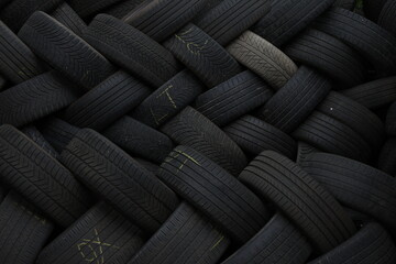 Close up of stacked used tires. Detailed view of worn vehicle tires stacked together in a storage area. © Photo Image 555