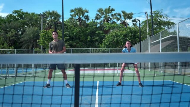 Young pickleball players competing in a doubles match on an outdoor court, demonstrating teamwork, athletic performance, and an active healthy lifestyle