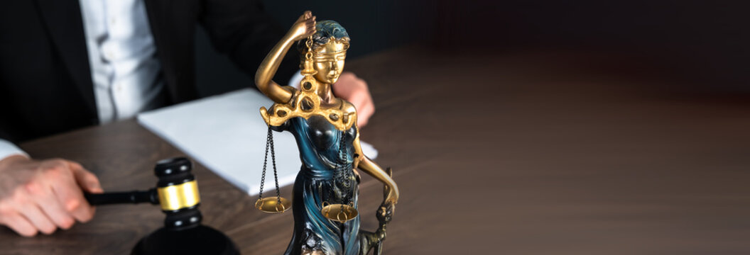 A judge&rsquo;s gavel, scales of justice, and judge writing documents, representing law, authority, rulings, and courtroom proceedings.