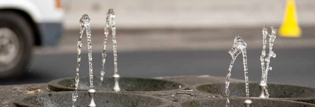 Public drinking water fountain providing clean potable water, symbolizing accessibility, hydration, urban infrastructure, and public health in a city environment.