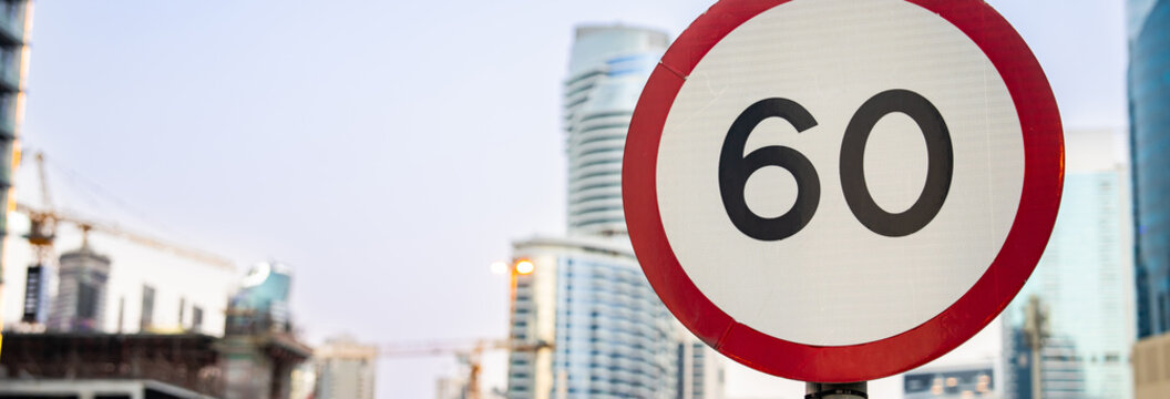 Road sign displaying maximum speed limit of 60 kilometers per hour on urban street, traffic regulation, driving safety, and transportation control concept.