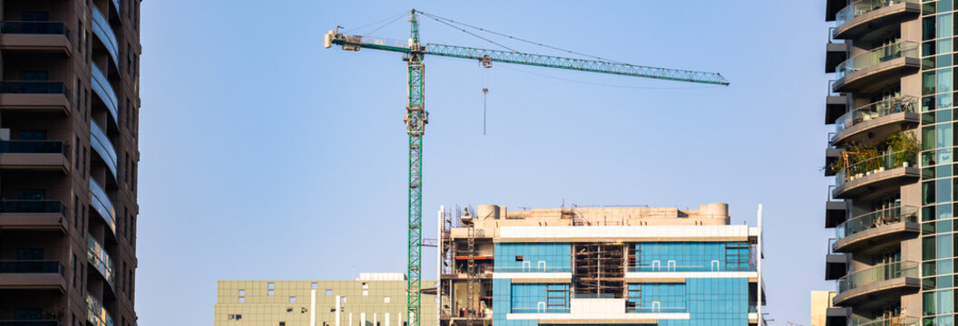 Modern construction site with new residential buildings under development, showing cranes, scaffolding, and workers, representing urban growth, infrastructure expansion, and real estate development.