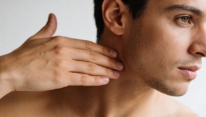 Fototapeta premium Touching shirtless male subject's neck, inspecting right profile at studio wall, showing stubble
