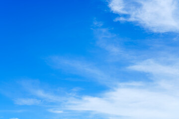 Obraz premium Vibrant blue sky background with soft white wispy clouds. Beautiful clear sunny day atmosphere with ample copy space for text. High quality natural landscape for web banners and print marketing.