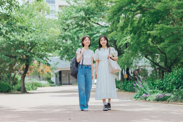 Obraz premium 大学のキャンパスを歩く女子大生二人組