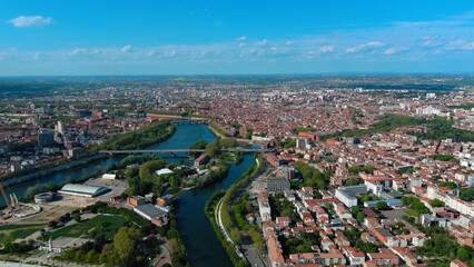 Obraz premium 4K aerial drone image of Toulouse, France. Panoramic summer cityscape featuring the River Garonne and historic red brick architecture.